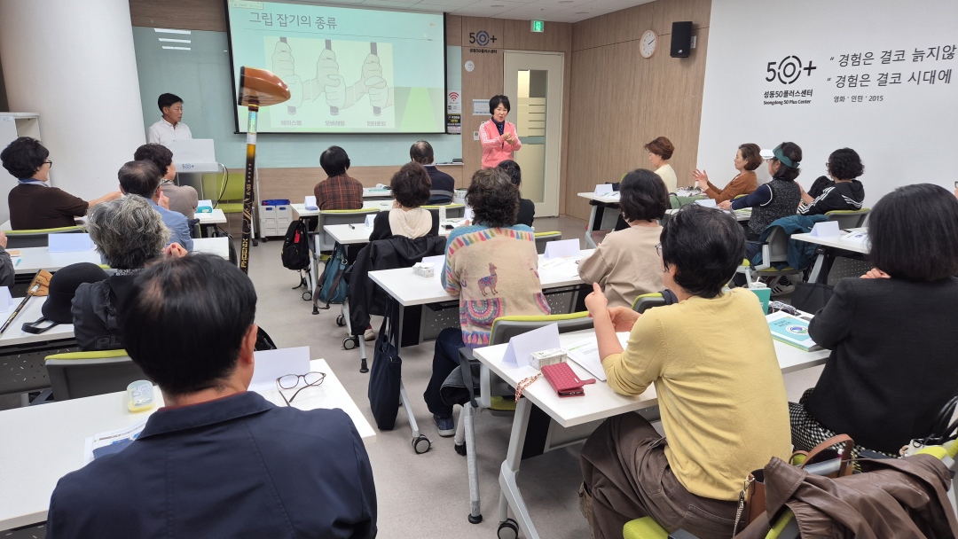 강사가 그립잡는 법을 시범을 보여주며 설명하고 있다